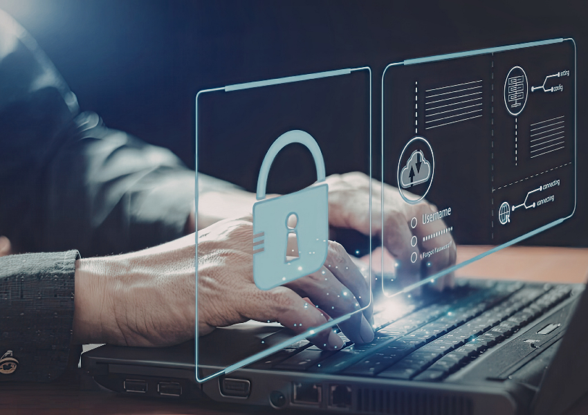 Close-up of hands typing on a laptop keyboard with transparent holographic security panels, login fields, cloud icons, and a padlock overlay. Futuristic visual representing online protection and secure access and business resilience.